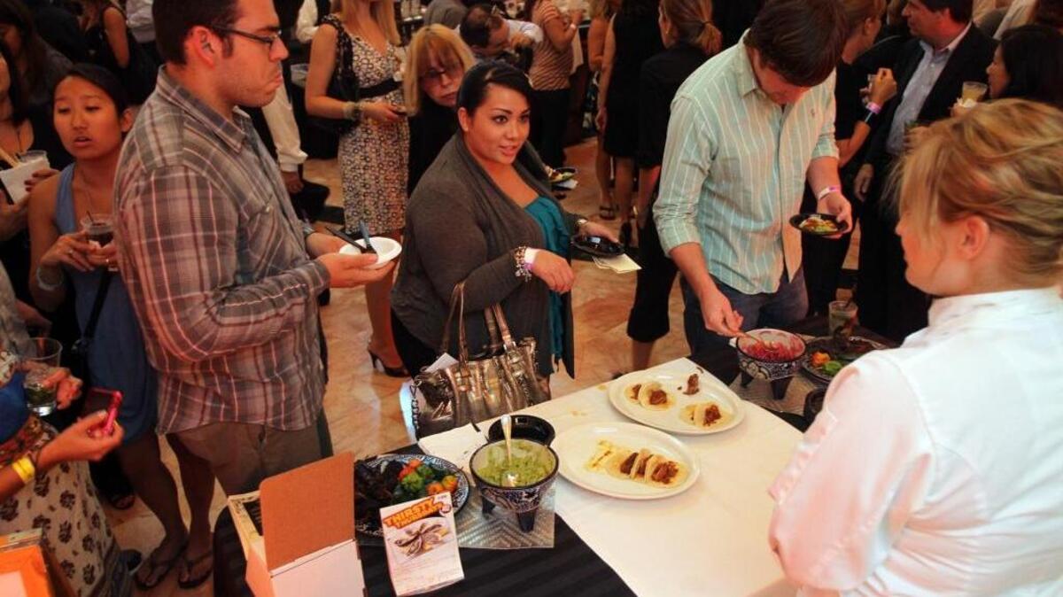 Vanessa Vallejo, in center, asks for a taste of the pork tacos from Jaguar Restaurant during the Taste Of The Gables at the Westin Colonnade in 2011.