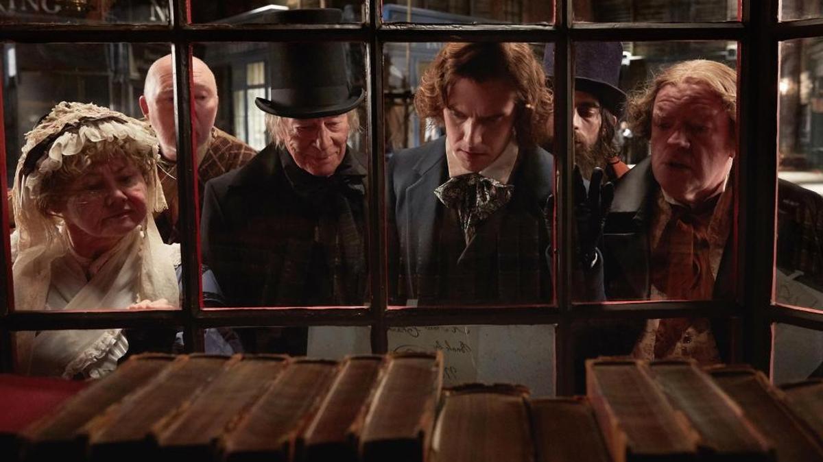 Christopher Plummer, center-left, stars as Ebenezer Scrooge, and Dan Stevens center-right, stars as Charles Dickens in director Bharat Nalluri’s ‘The Man Who Invented Christmas.’