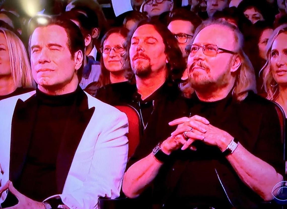 John Travolta, Ashley Gibb and Barry Gibb sit in the front row for a taping of a Bee Gees tribute in this screengrab from CBS’ broadcast of “Stayin’ Alive: A Grammy Tribute to the Bee Gees” on Sunday, April 16, 2017.