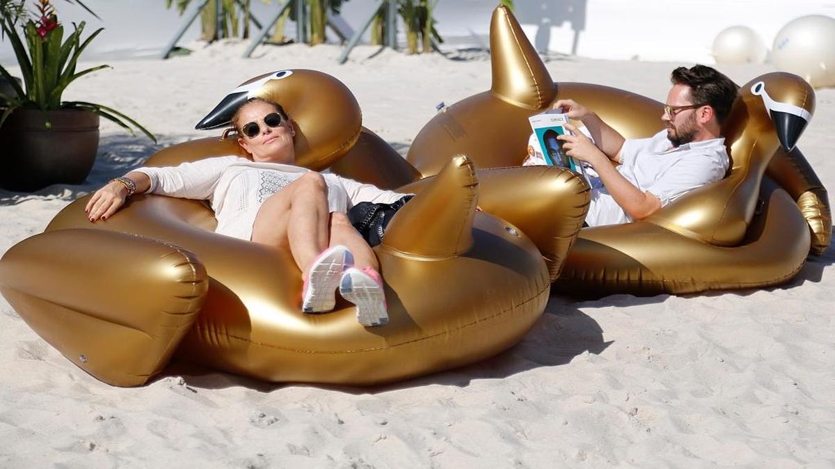 German visitors Susie Von den Stemmen, left, and Alexander Battle-Lachmann take advantage of the wonderful weather outside Design Miami pavilion as they and many others enjoy the first day of Art Basel.