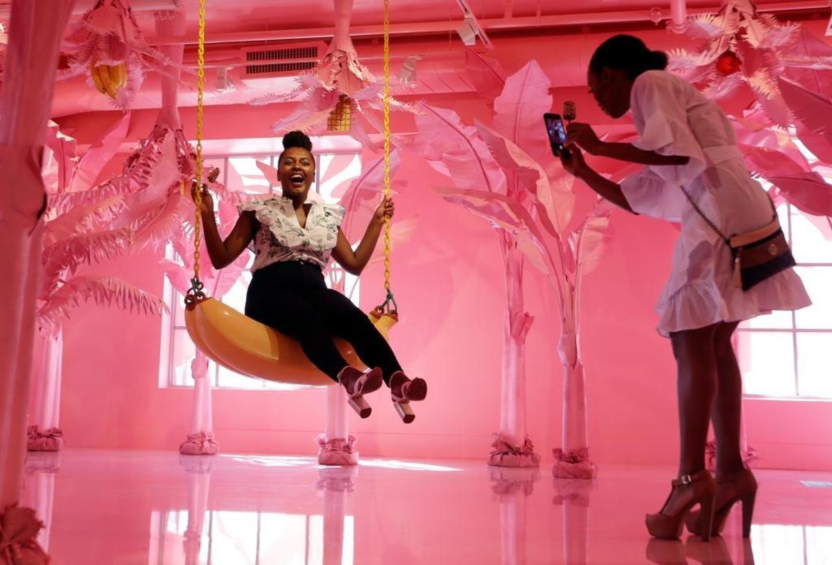 Stephanie Cruz, left, is photographed by Chloe Herring, right, while on a giant banana swing at The Museum of Ice Cream, Thursday, Dec. 7, 2017, in Miami Beach, Fla. The museum is one of several in the U.S. and opened as a pop-up to coincide with Art Basel events going on throughout the week.