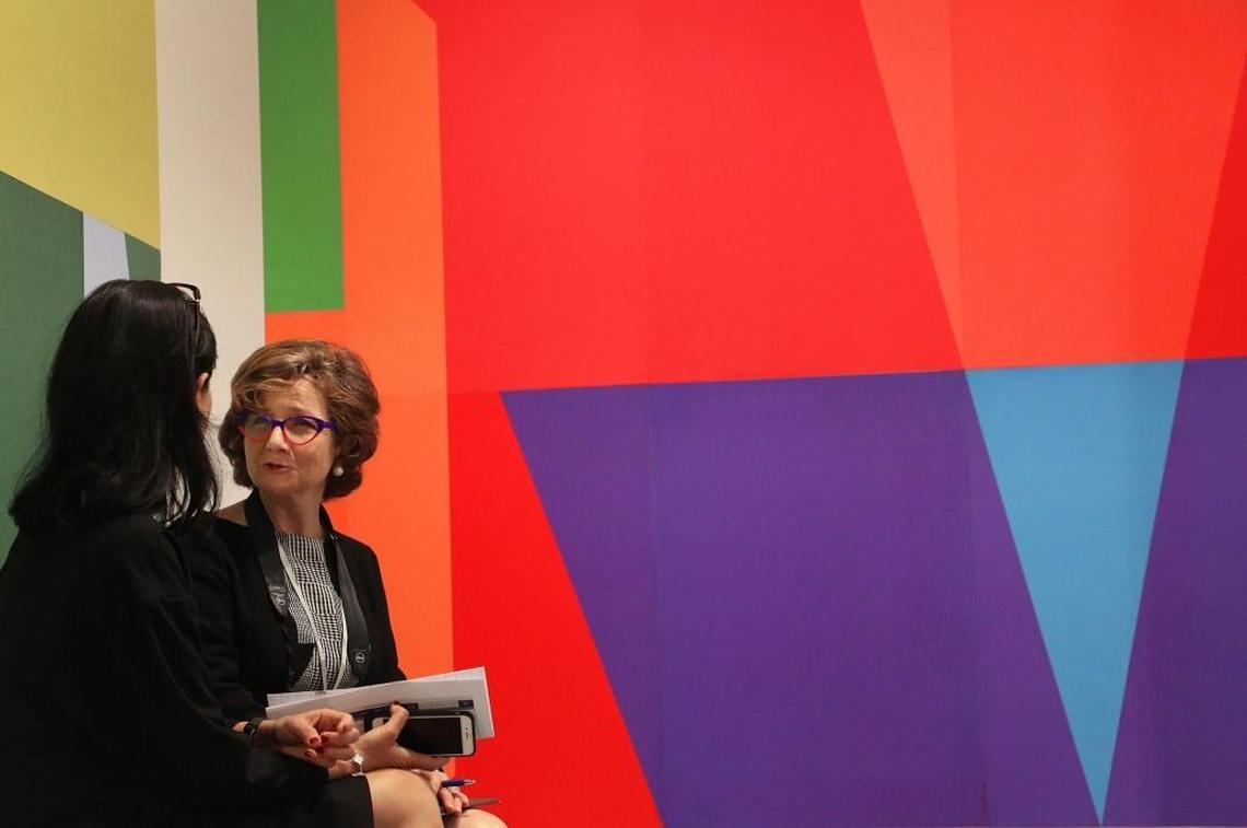 Rita Targul, director of STPI Gallery of Singapore, left, and Mary Leadbetter, a former Singapore resident, talk in front of a work by Tobias Rehberger during the VIP opener at Art Basel Miami Beach fair on Wednesday.