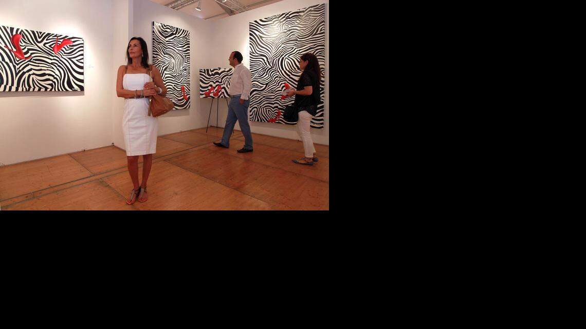 
Ghada Dergham looks at the art work of the Zebra Love exhibit by Blake Emory, a concept work in 'Optic Modernism, at the Spectrum art fair, Saturday, Dec. 6, 2014, in Midtown Miami.
