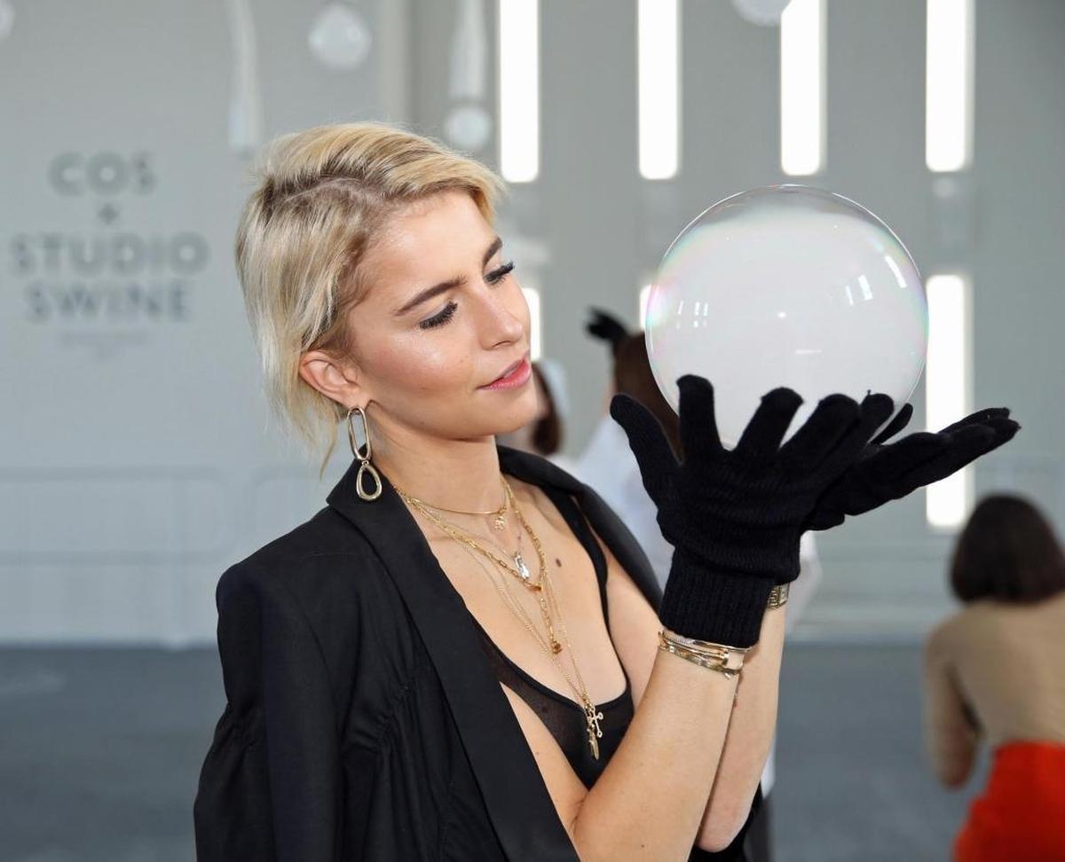 German fashion model Caroline Daur on Tuesday, Dec. 5, 2017, handles mist-filled blossoms that burst and evaporate on contact with skin, but that live on momentarily when met with textured fabrics at DesignMiami/ 2017 installation by Cos clothing company and exhibit designers Studio Swine. It’s at 1415 Euclid Avenue, the space called Temple House in Miami Beach.