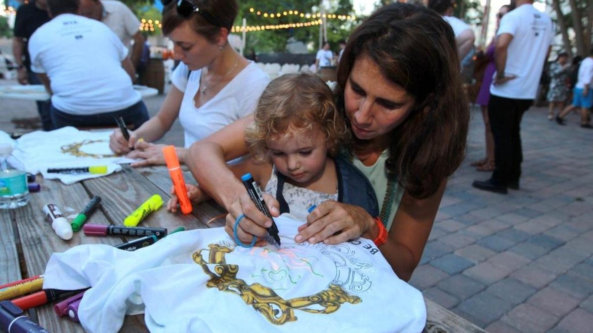 
Cristina Estebanez, draws on a T-shirt with her daughter, Ines Villegas, at a kickoff event Sept. 2 for the fourth annual Art Days in downtown Miami Sept. 11-13. 
