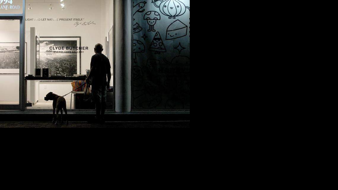 Show space:  Famous Everglades photographer Clyde Butcher is opening up a gallery in Coconut Grove. Here, a local and his dog peer into the gallery.