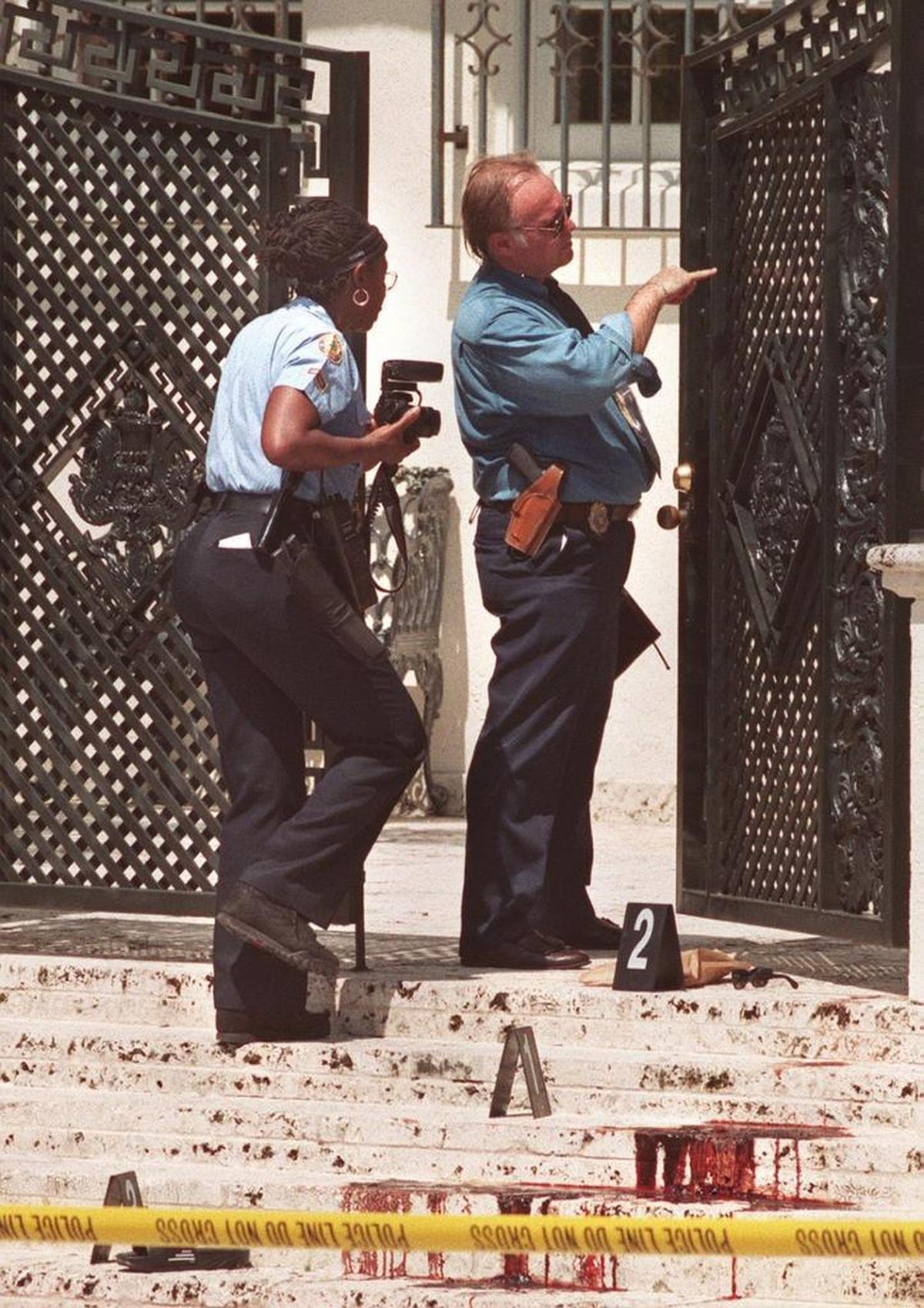 Police investigate the bloody steps and gate in front of Gianni Versace's mansion on Ocean Drive in Miami Beach on July 15, 1997, the date the Italian fashion designer was gunned down and killed.