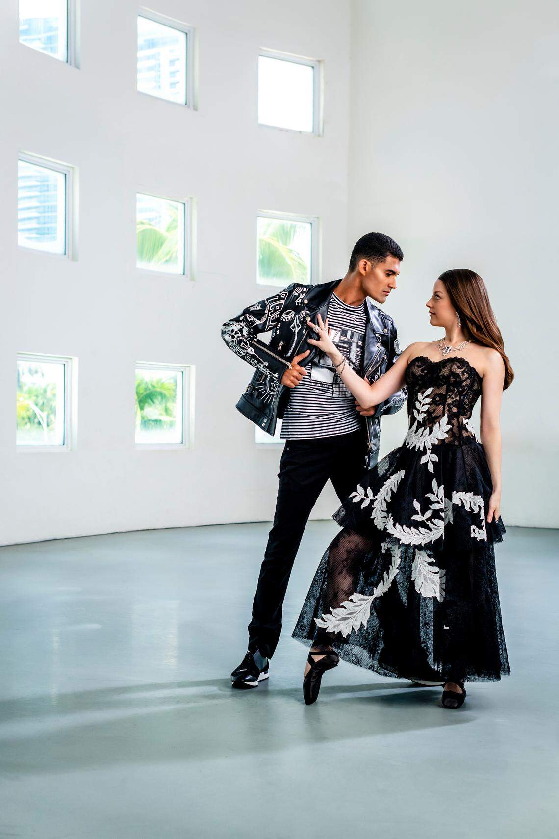 On Renan: Moto jacket by Diesel Black Gold, T-shirt by Balmain, jeans by Diesel, sneakers by Balenciaga from Saks Fifth Avenue at Brickell City Centre. On Jennifer: Gown by Oscar de la Renta at Bal Harbour Shops; jewelry by Orianne Collins at Miami Design District. Photograph by Nick Garcia.