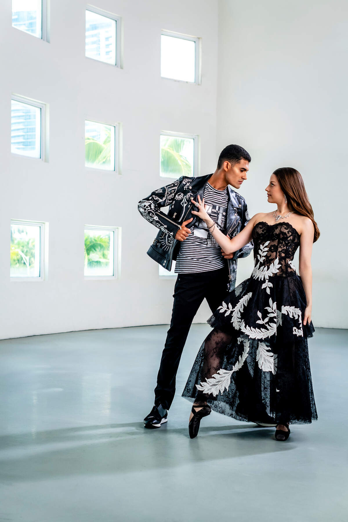On Renan: Moto jacket by Diesel Black Gold, T-shirt by Balmain, jeans by Diesel, sneakers by Balenciaga from Saks Fifth Avenue at Brickell City Centre. On Jennifer: Gown by Oscar de la Renta at Bal Harbour Shops; jewelry by Orianne Collins at Miami Design District. Photograph by Nick Garcia.