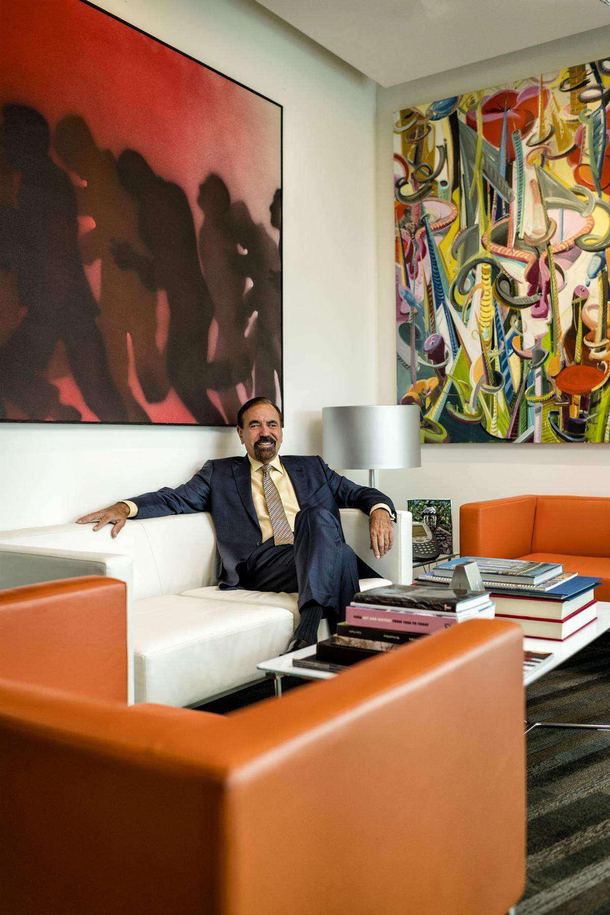 Jorge Pérez sits at his office beneath paintings by Juan Genovés (Ideograma 139, left) and Tomás Esson (Yo Sigo Pintando/Oraculo, right). Photograph by Nick Garcia.