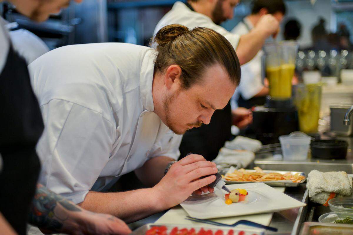 Brad Kilgore plates a dish during his collaboration dinner with Will Goldfarb. Photograph by Felipe Cuevas.