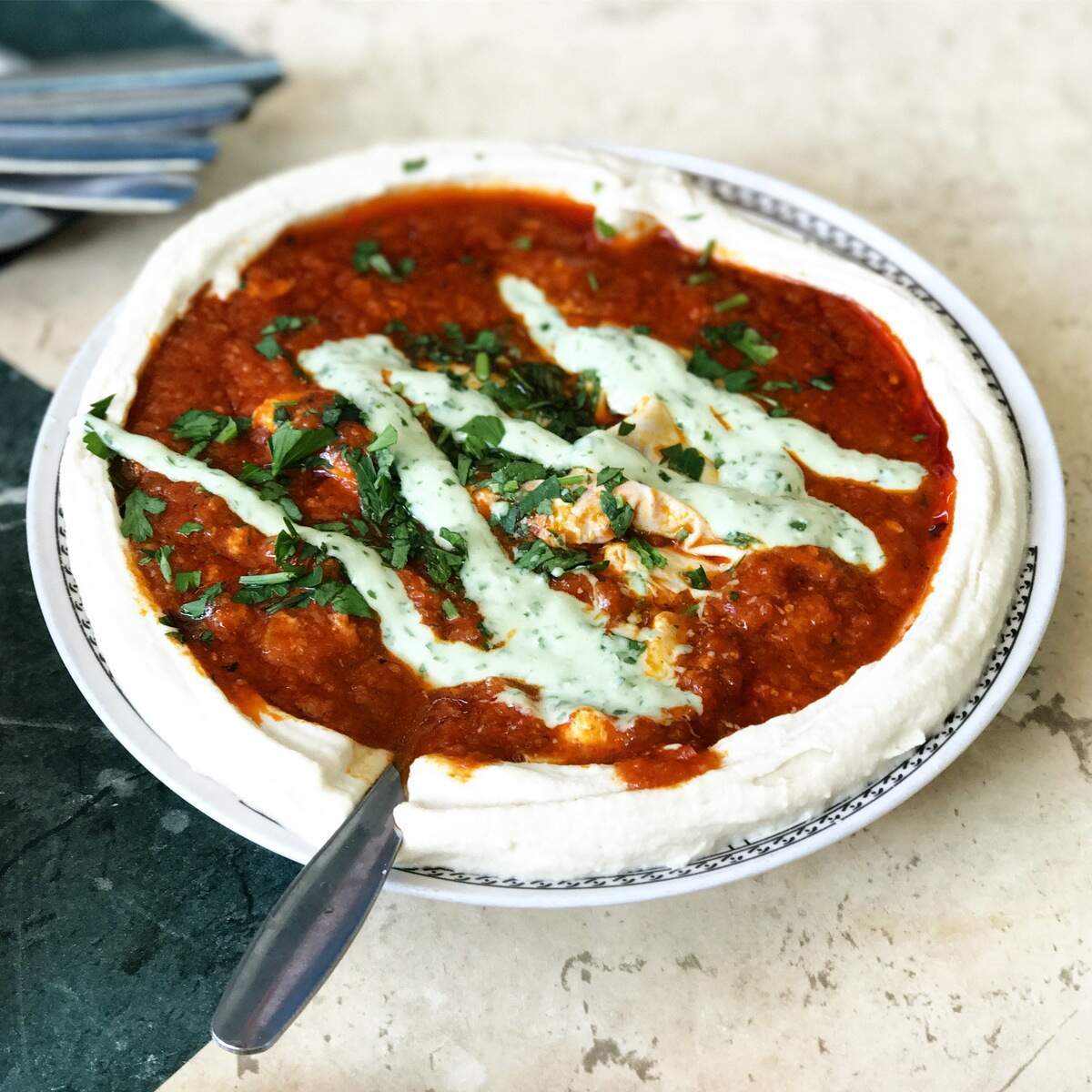 Shakshuka in a hummus-lined bowl at Shlomo and Doron near the Carmel Market in Tel Aviv. Photograph by Evan S. Benn.