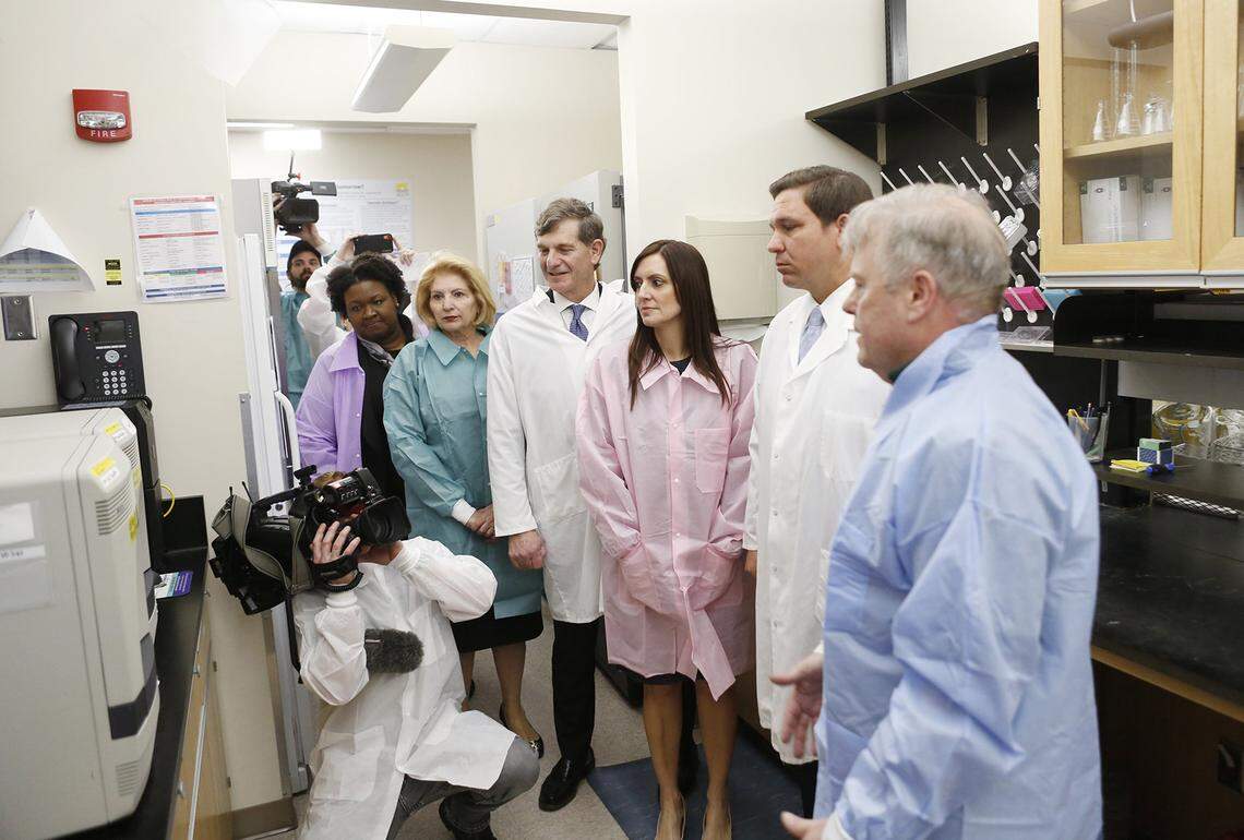 From left, Deputy Secretary for Health Shamarial Roberson, state Sen. Janet Cruz, Surgeon General Dr. Scott Rivkees, Lt. Gov. Jeanette Nuñez and Gov. Ron DeSantis look on while Andrew Cannons, laboratory director at the Bureau of Public Health Laboratories, explains the testing procedures of potential coronavirus cases on March 2, 2020, at the Florida Department of Health Laboratory in Tampa.