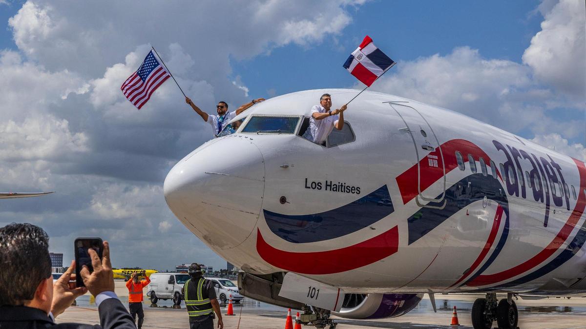 Co-Pilot Robert Pena (left) and CEO Victor Pacheco Mendez, wave US and Dominican Republic flags at the first Arajet Airlines, arrive at Miami International Airport. Arajet is the flagship carrier of the Dominican Republic, marking a major milestone for both the airline and the Dominican aviation industry, on Friday April 11, 2025.