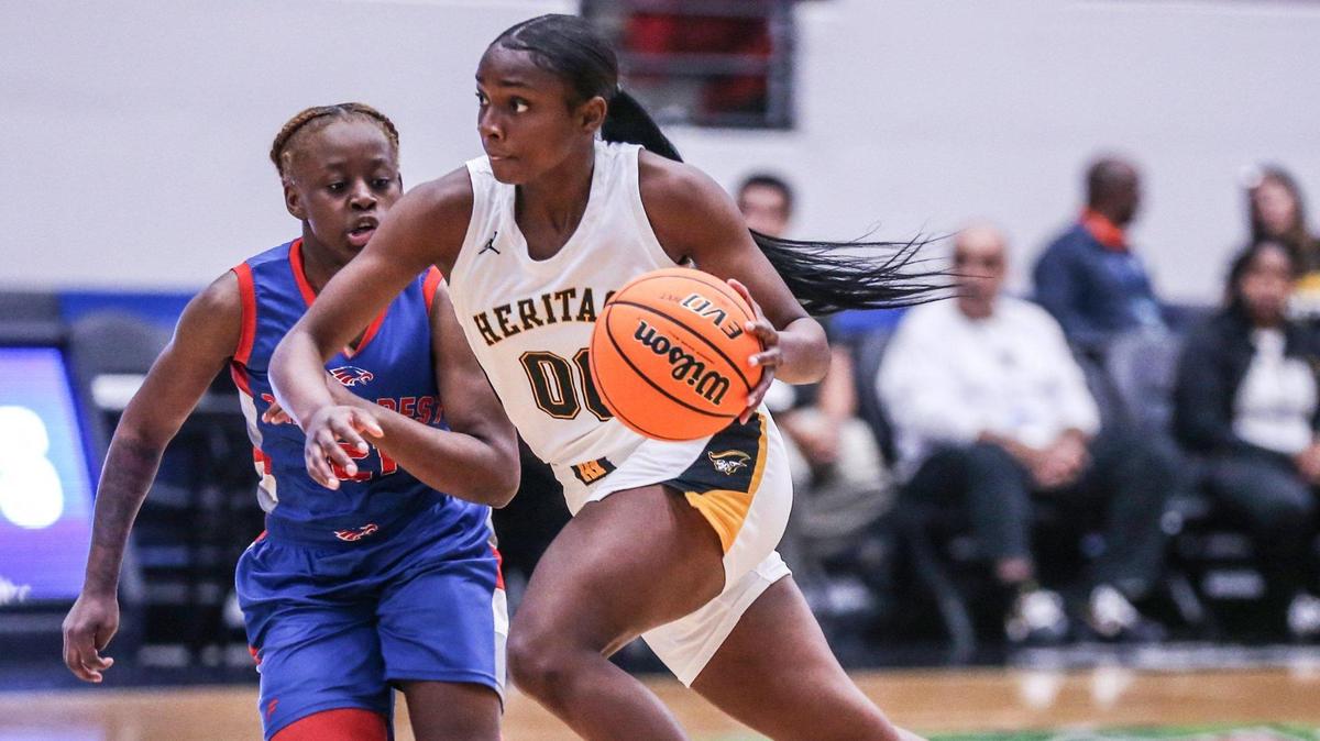American Heritage Ta’ Niya Latson (00) drives the ball as Pine Forest’s Makevia House (21) defends in a girls basketball Class 5A state semifinal at the RP Funding Center in Lakeland on Thursday, February 24, 2022.