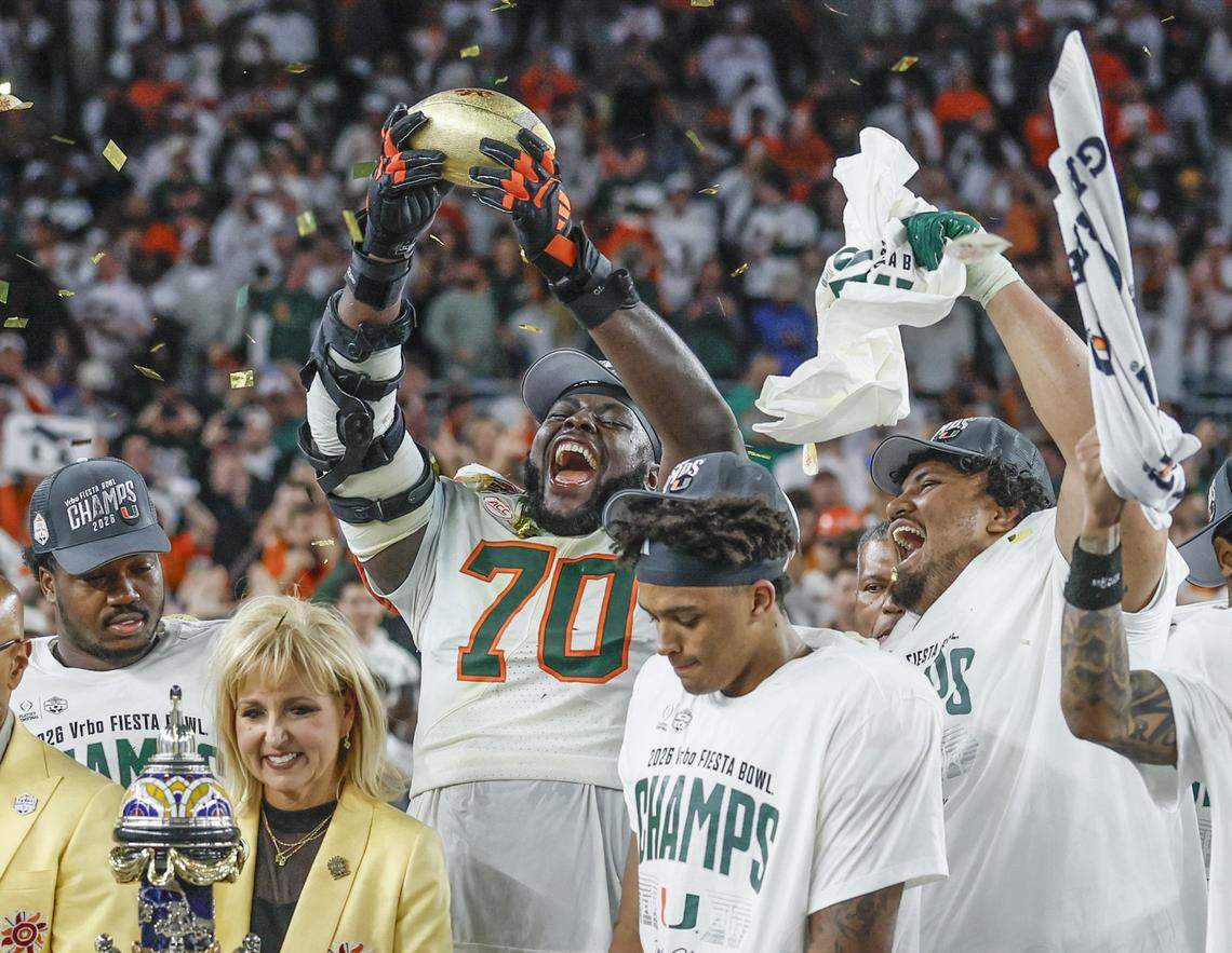 Miami Hurricanes offensive lineman Markel Bell (70) raises the diamond-encrusted football that is fully removable from the Fiesta Bowl Trophy, as the team celebrates on stage after defeating the Mississippi Rebels in the College Football Playoff semifinal at the Fiesta Bowl at State Farm Stadium on Friday, January 9, 2026 in Glendale, Arizona.