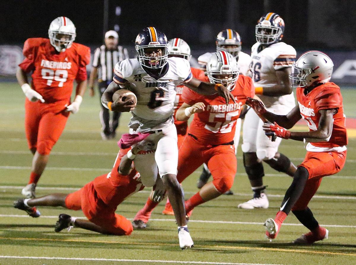 Homestead Broncos running back Tyrone Maxwell (6) escapes a tackle by Doral Academy defenders during football game on Thursday, October 14, 2021 at Doral Academy in Doral
