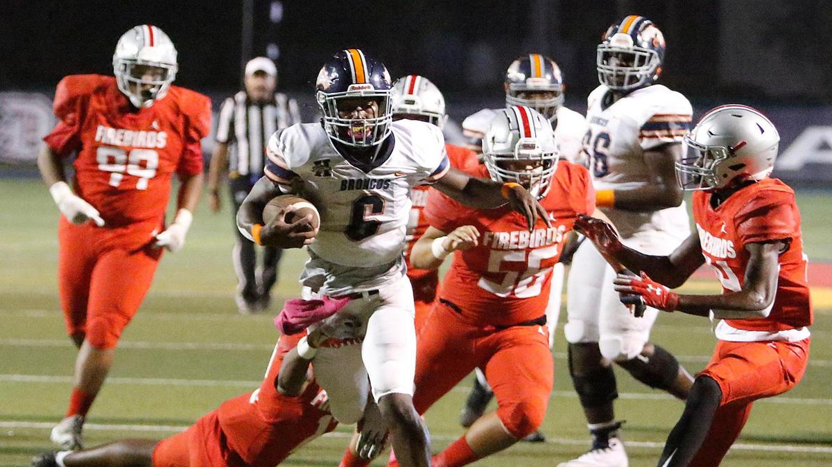 Homestead Broncos running back Tyrone Maxwell (6) escapes a tackle by Doral Academy defenders during football game on Thursday, October 14, 2021 at Doral Academy in Doral
