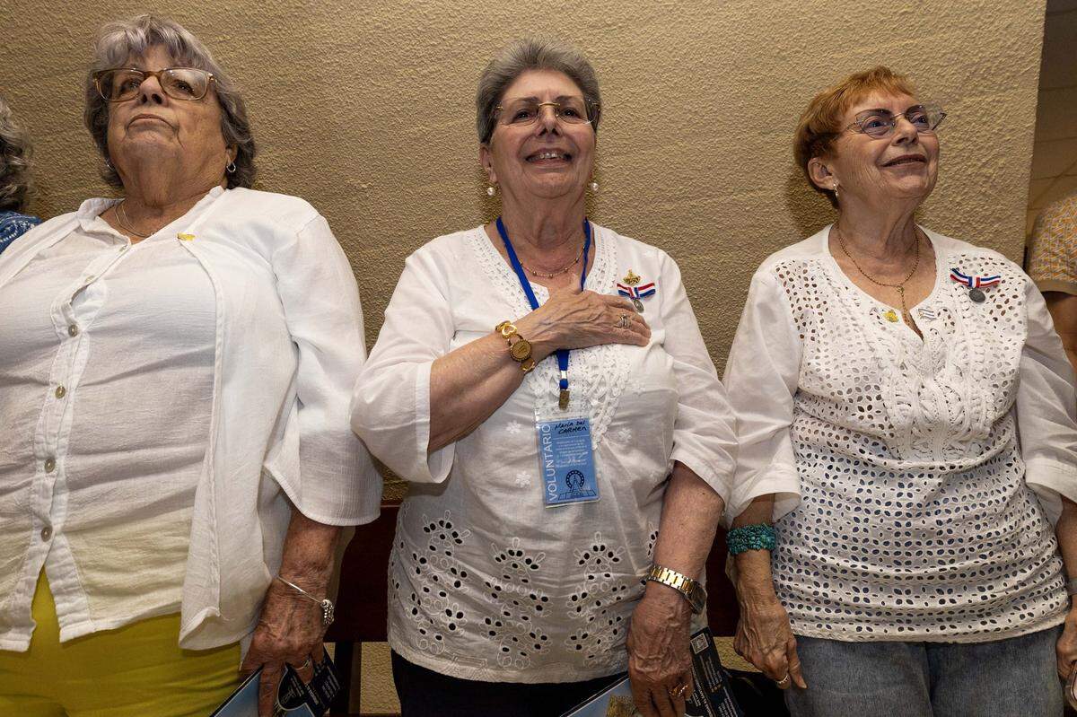 Congregants stand for the Pledge of Allegiance inside Ermita de la Caridad during the annual celebration of the feast day of Cuba's patroness, Our Lady of Charity, at the National Shrine of Our Lady of Charity, on Monday, September 8, 2025, in Coconut Grove, Fla.