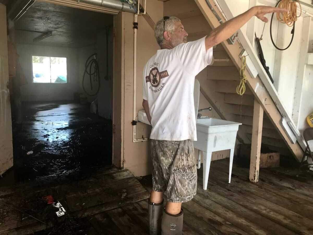 Rick Tooke of St. Marks holds his hand up to indicate where the water line was during the storm surge at his crabbing shop, which is right along the St. Marks River leading to the Gulf.
