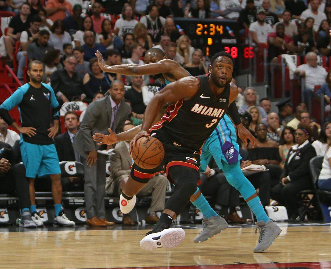 Miami Heat guard Dwyane Wade drives to the basket against Charlotte Hornets guard Kemba Walker in the first quarter of an NBA basketball game at AmericanAirlines Arena on Saturday, Oct. 20, 2018 in Miami.