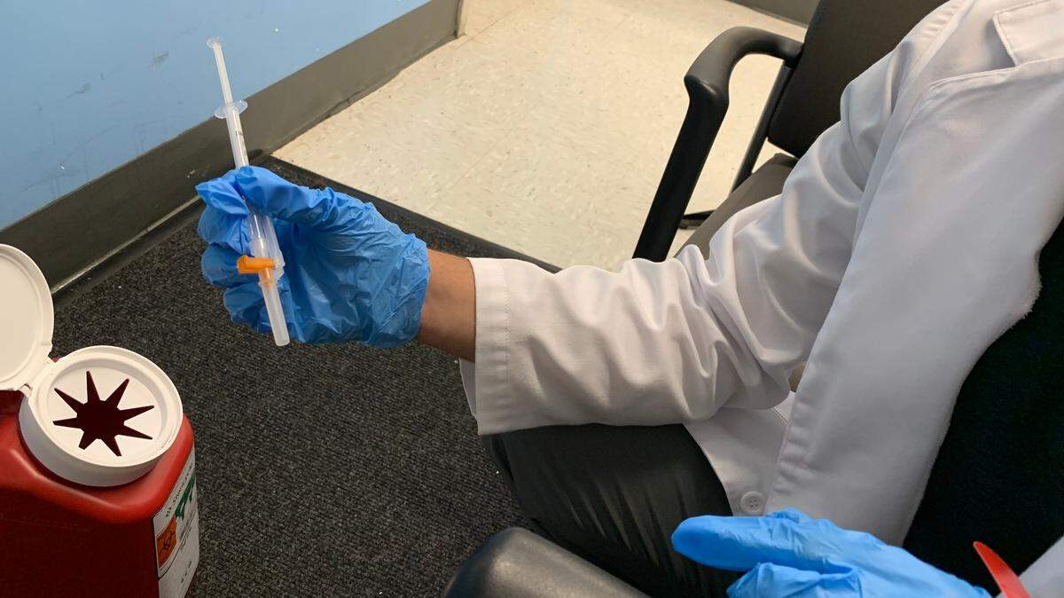 A pharmacist at a Miami-Dade County Walgreens prepares to give a patient an injection of the newly updated COVID-19 booster that is designed to target the original COVID strain, as well as Omicron BA.4 and BA.5, on Sept. 7, 2022.