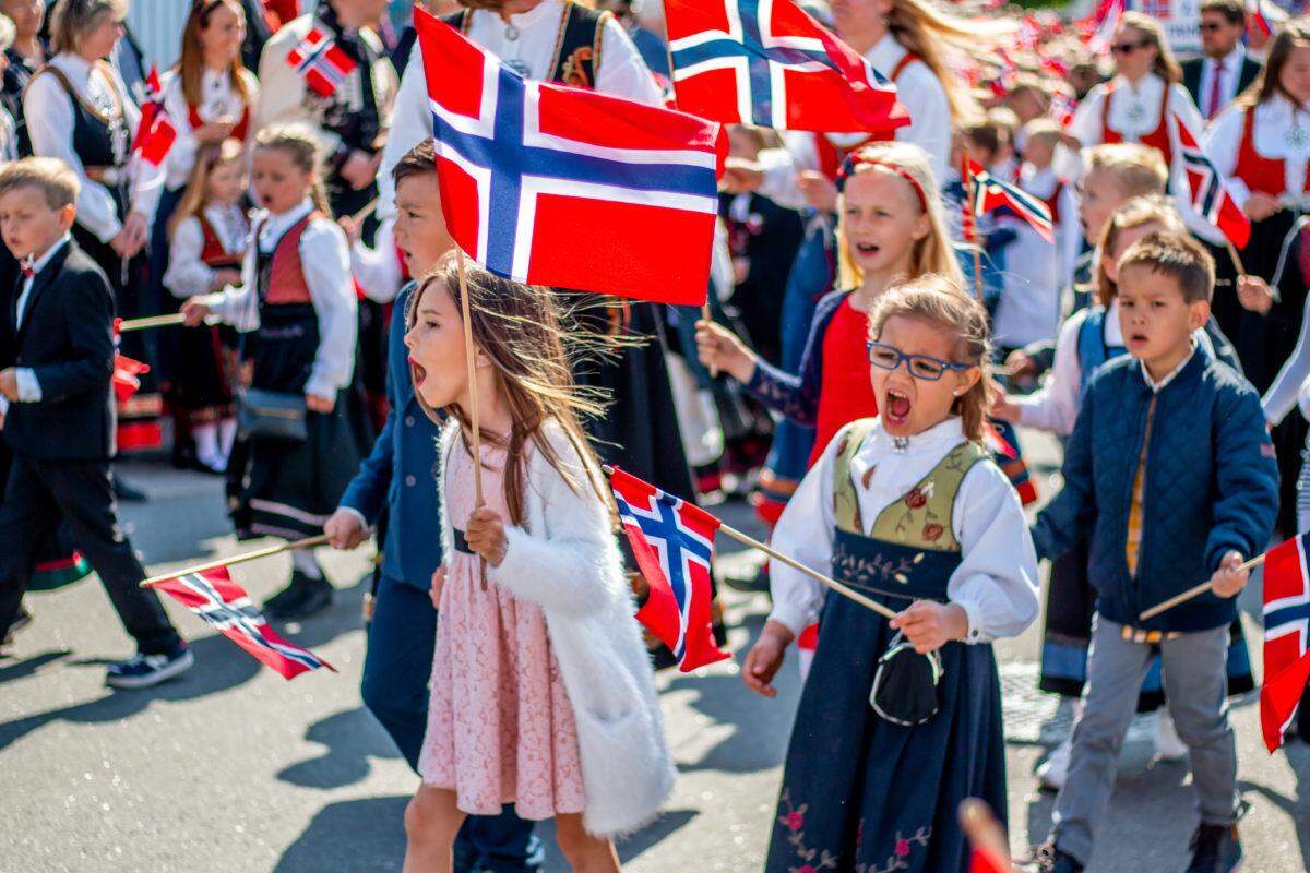 children marching down street with norway flags