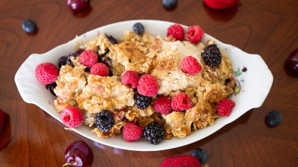 A berry crisp topped with oatmeal and brown sugar is filled with lush berries and easy to make.
