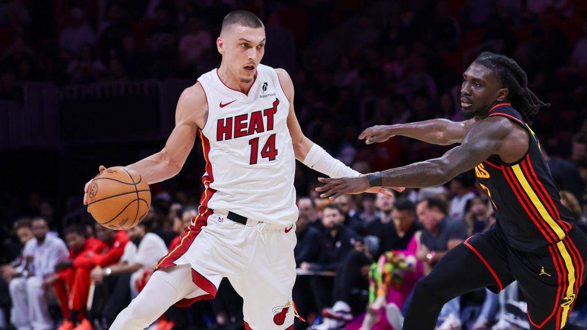 Heat guard Tyler Herro, left, dribbles pass Hawks guard Keaton Wallace during the first half of Heat vs. Hawks in the last game of the regular season at Kaseya Center on Sunday, April 12, 2026 in Miami.