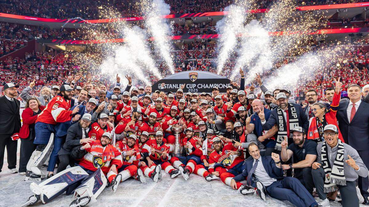 Florida Panthers players and staff gather for a team photo around the Stanley Cup after they defeated the Edmonton Oilers in Game 6 of the Final series at Amerant Bank Arena on Tuesday, June 17, 2025, in Sunrise, Fla.