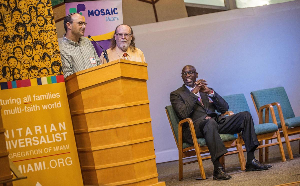 Rabbi Jeremy Barras, senior rabbi at Temple Beth Am in Pinecrest, left, and Dr. Walter Richardson, seated, the former senior pastor of Sweet Home Missionary Baptist Church in Cutler Bay, joined Rev. Tom Capo, center, minister of the Unitarian Universalist Congregation of Miami, as they welcomed attendees to an Interfaith Potluck to combat hate, antisemitism in South Florida amid the Israel-Hamas war, Sunday, Oct. 22, 2023.