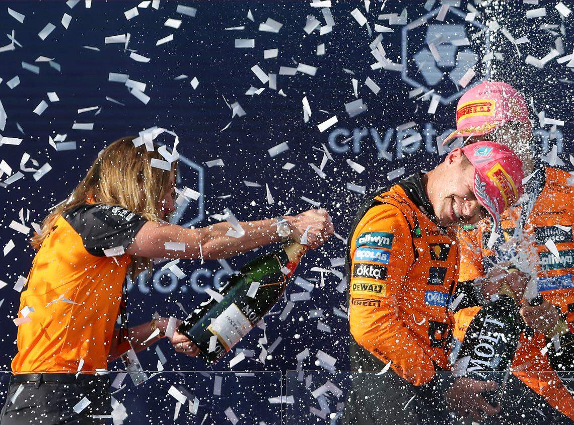 McLaren chief marketing officer Louise McEwen sprays champagne on McLaren drivers Oscar Piastri of Australia and Lando Norris of Britain during the trophy ceremony at the Formula One Miami Grand Prix at the Miami International Autodrome on Sunday, May 4, 2025, in Miami Gardens, Fla.