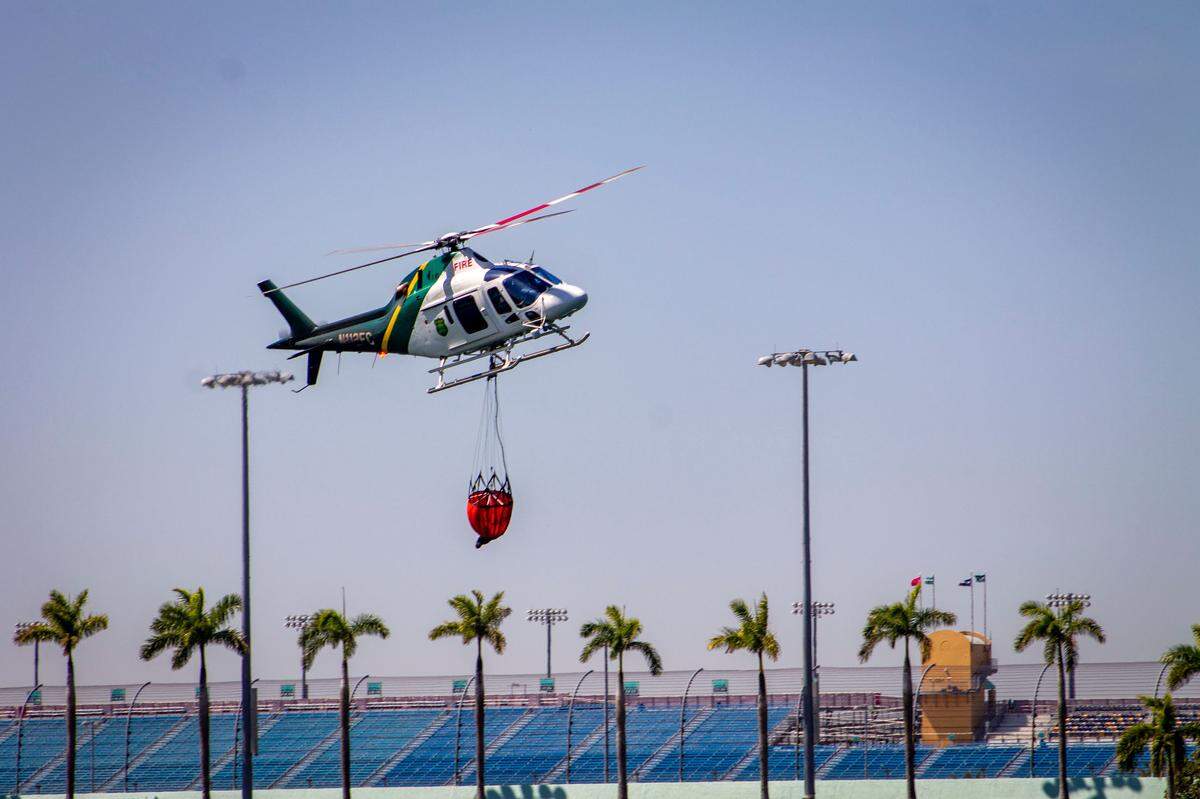 Homestead, FL- Florida Forest Service Helicopter gathers water from a retention pond behind Homestead Speedway Friday, March 21, 2025, to fight nearby wildfires in south Miami-Dade County.