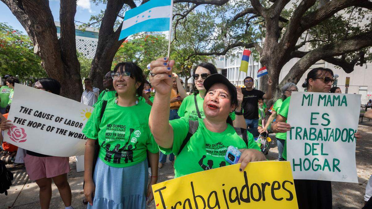 Ericka Varela (center) from Honduras holds the Honduras flag during an event to commemorate International Domestic Workers’ Day. Domestic workers gathered at Miami-Dade Government Center to demand fair wages, protections, and respect. The event was organized by WeCount! and The Women’s Fund Miami-Dade, June 16, 2025.