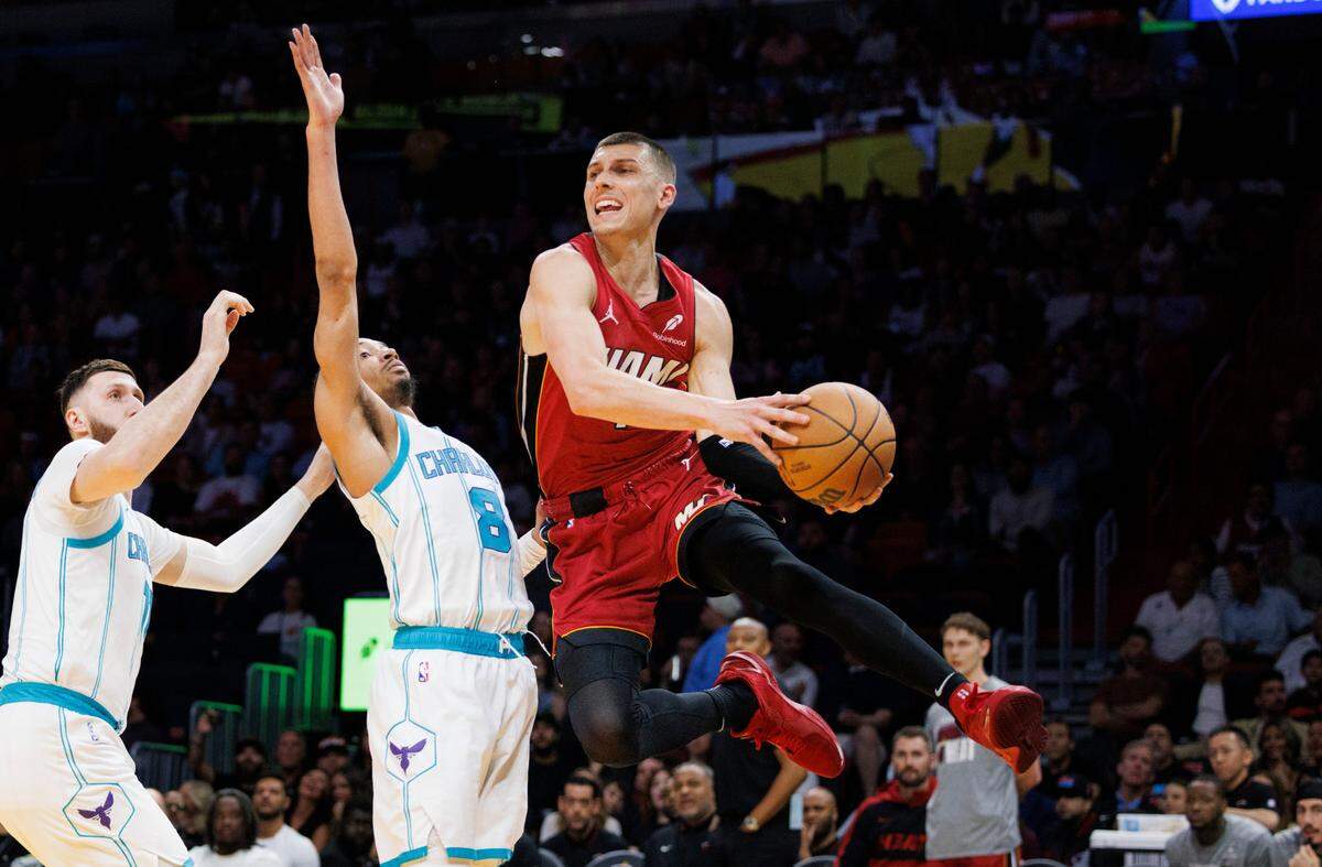 Miami Heat guard Tyler Herro (14) jumps around Charlotte Hornets guard Nick Smith Jr. (8) and Charlotte Hornets center Jusuf Nurkic (11) during the second half of a game on Monday, March 10, 2025, at the Kaseya Center in downtown Miami, Fla.