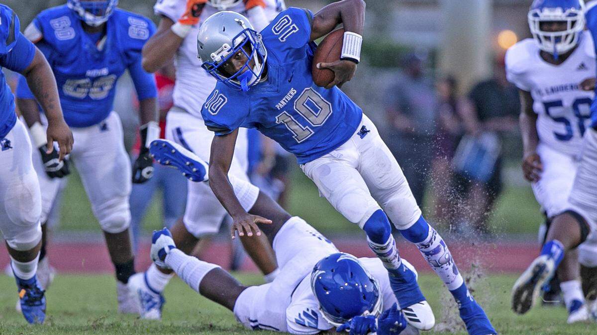 Dillard quarterback Zamir Jones (10) breaks a tackle in the first quarter as Dillard High School hosts Fort Lauderdale High in Fort Lauderdale on Friday, August 16, 2019.