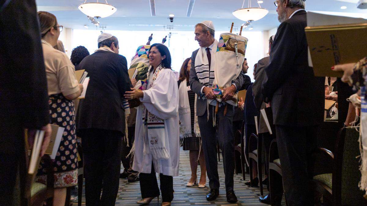 Rabbi Judith Lazarus Siegal and Mark Kass, president of the synagogue, parade the Torahs during the ‘hakafah’ as congregants touch the holy book with their ‘siddurim’, or prayer books, during Rosh Hashana services at Temple Judea in Coral Gables, Florida, on Saturday, Sept. 16, 2023.,the first full day of the Jewish New Year.