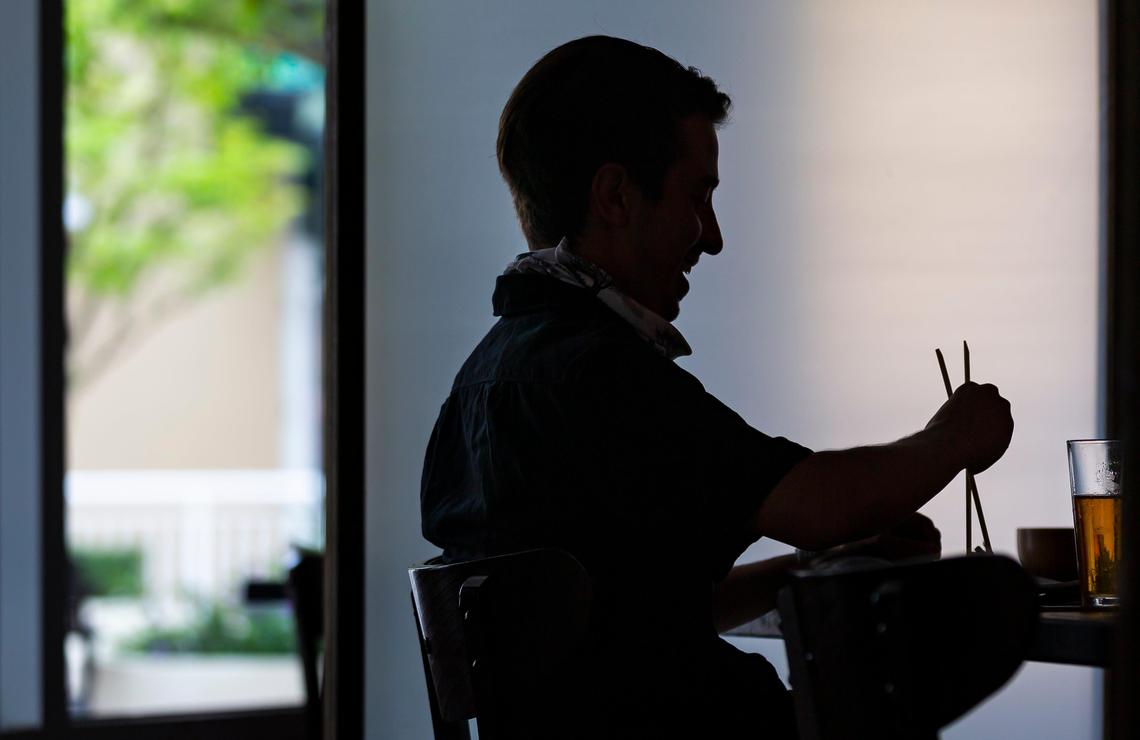 Herbert Eckardt, 26, eats lunch with his coworkers at Pubbelly Sushi in Dadeland on the first day Miami-Dade County allowed restaurants to reopen their dining rooms on Monday, May 18, 2020. In order to control the spread of the coronavirus, Miami officials prohibited restaurants from operating their dining rooms on March 16, 2020.