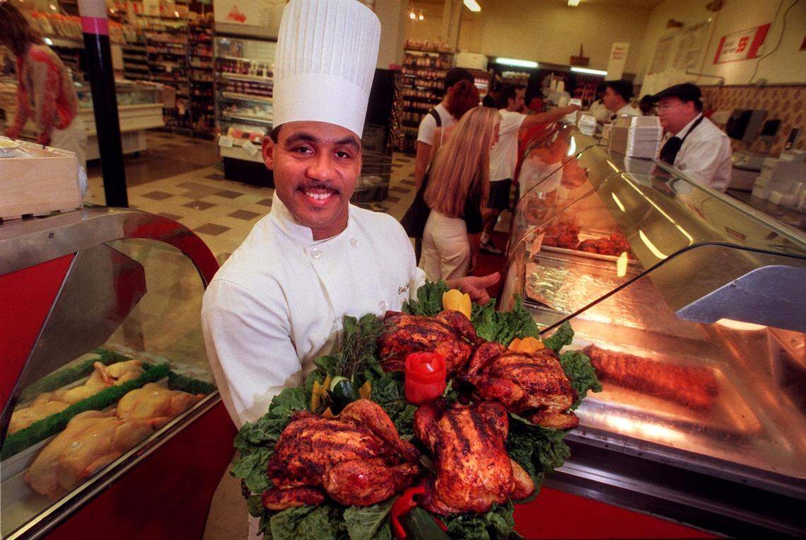 Epicure chef Jose La-Boissiere holds a tray of roasted chickens next to Miami Beach’s Epicure’s hot meal station.