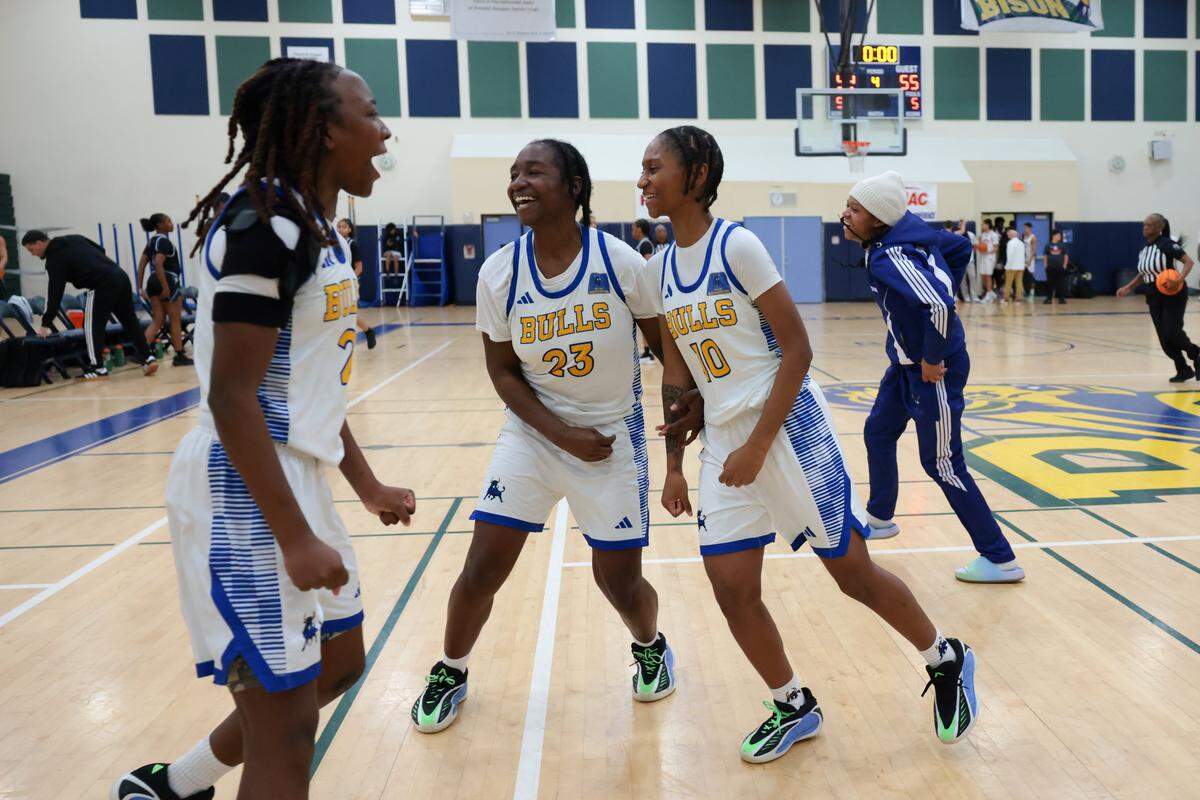 Northwestern Bulls Arianna Jean Baptiste (23) and Damaria Gatlin (10) celebrate after defeating the South Dade Buccaneers during overtime in the Greater Miami Athletic Conference girls basketball finals game at Ronald W. Reagan Doral Senior High School on Saturday, Jan. 24, 2026, in Doral, Fla.