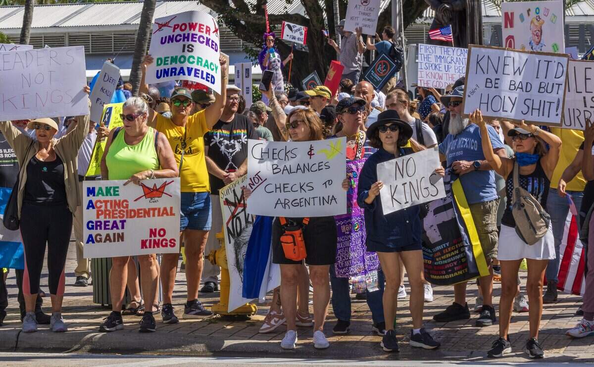 Protesters with signs at the Miami Torch of Friendship in downtown Miami during the ‘No Kings’ anti-Trump protests on Oct. 18, 2025.