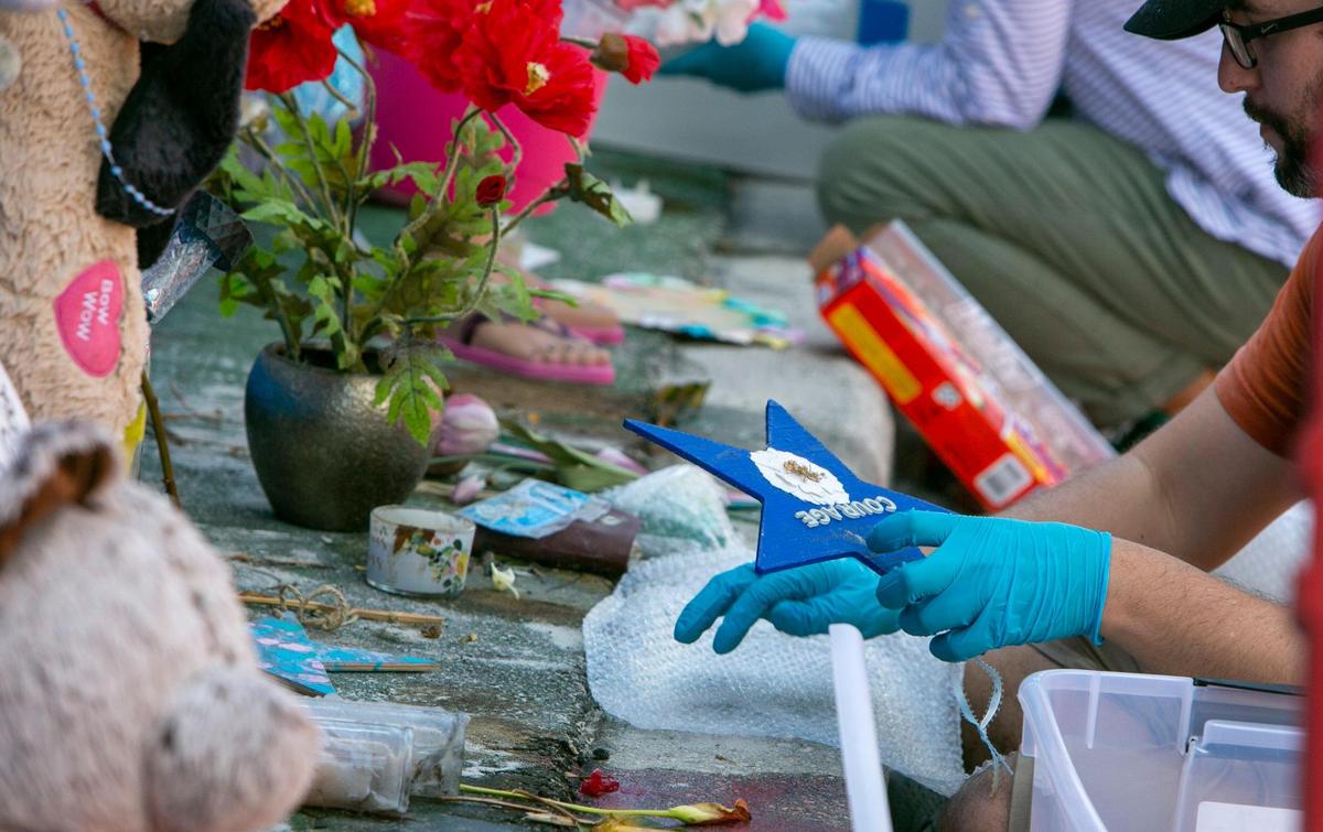 A worker for HistoryMiami wraps up an item from the Surfside memorial on Monday, August 30, 2021.
