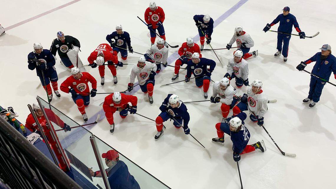 Florida Panthers players huddle on the ice while interim coach Andrew Brunette explains a drill during practice on Monday, Dec. 27, 2021, at the Panthers IceDen in Coral Springs, Florida.