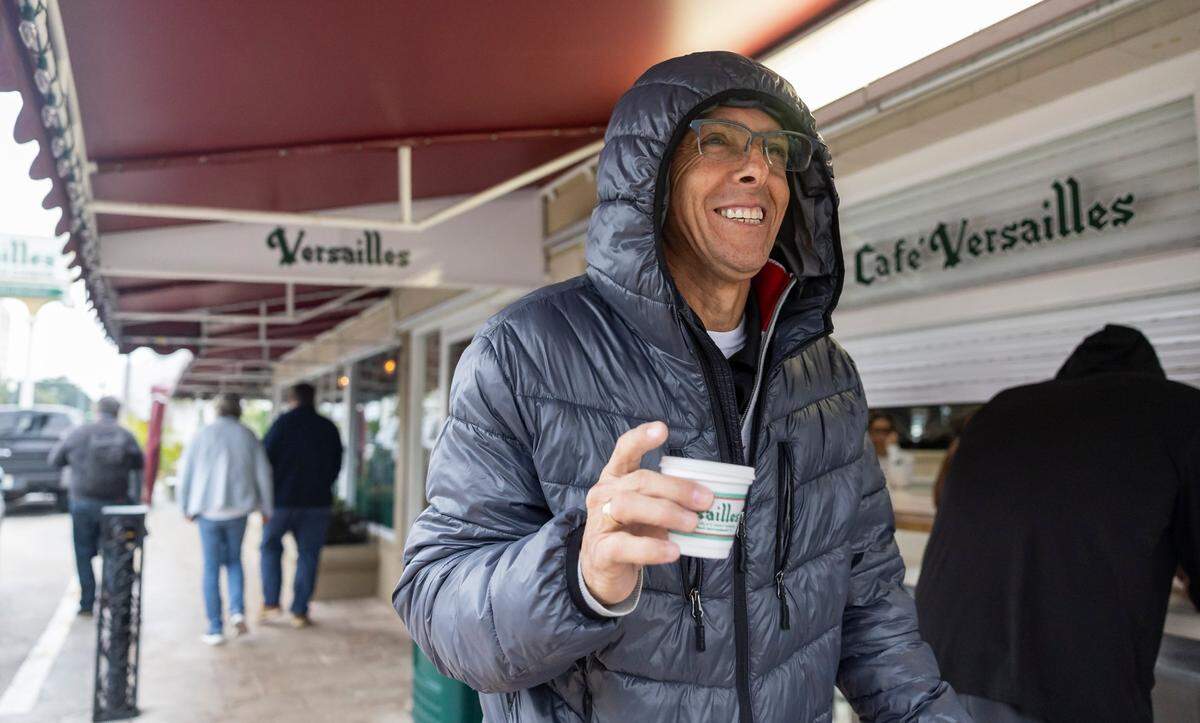 Andres Lozano leaves Versailles Restaurant Cuban Cuisine with his coffee as temperatures dip into the mid 40s across South Florida on Friday, Jan. 24, in Miami, Fla.