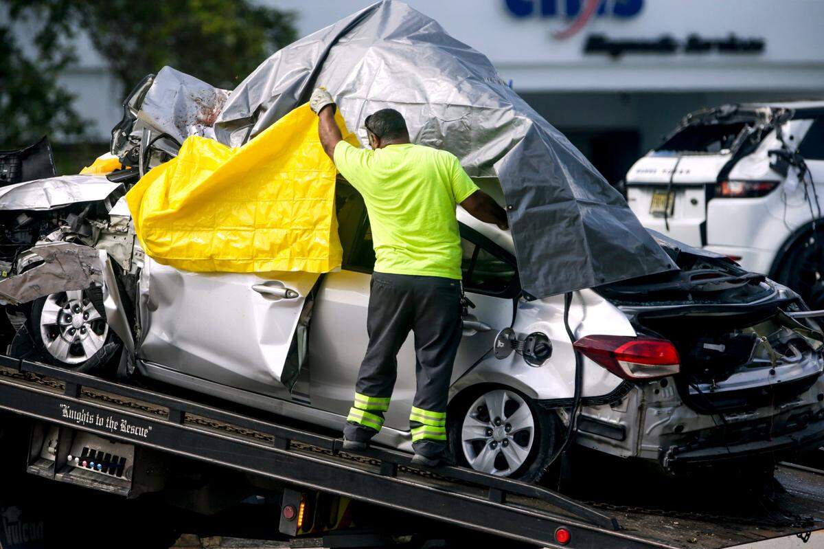 A vehicle involved in a fatal accident near the intersection of Sunset Drive and Southwest 92nd Avenue in South Miami is covered with a tarp before getting towed away. Three people were killed and one taken to the hospital on Tuesday, Aug. 31, 2021.