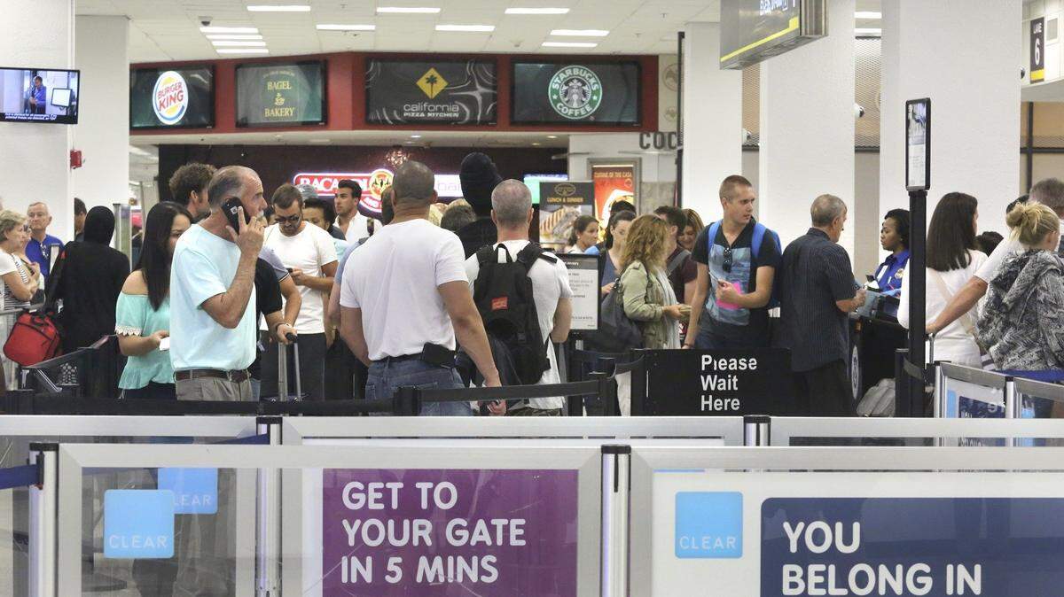 Passengers stand in line to pass through TSA security at Checkpoint E at Miami International Airport on Saturday afternoon, Sept. 10, 2016.