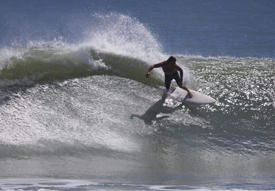 A local surfer catches a wave during the morning on Thursday, Aug. 21, 2025, off the beach in Stuart, Fla. Surfers estimated that waves ranged from 8 - 12 feet all morning.