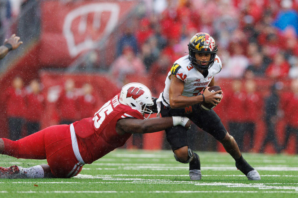 Nov 5, 2022; Madison, Wisconsin, USA; Maryland Terrapins quarterback Taulia Tagovailoa (3) is sacked by Wisconsin Badgers nose tackle Keeanu Benton (95) during the first quarter at Camp Randall Stadium. Mandatory Credit: Jeff Hanisch-USA TODAY Sports