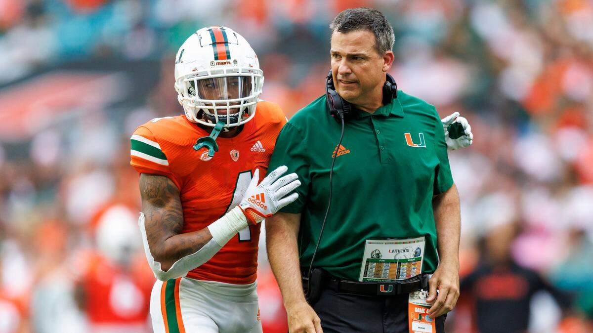 Miami Hurricanes head coach Mario Cristobal talks with running back Jaylan Knighton (4) during the second quarter of an ACC conference football game against North Carolina Tar Heels at Hard Rock Stadium on Saturday, October 8, 2022 in Miami Gardens, Florida..