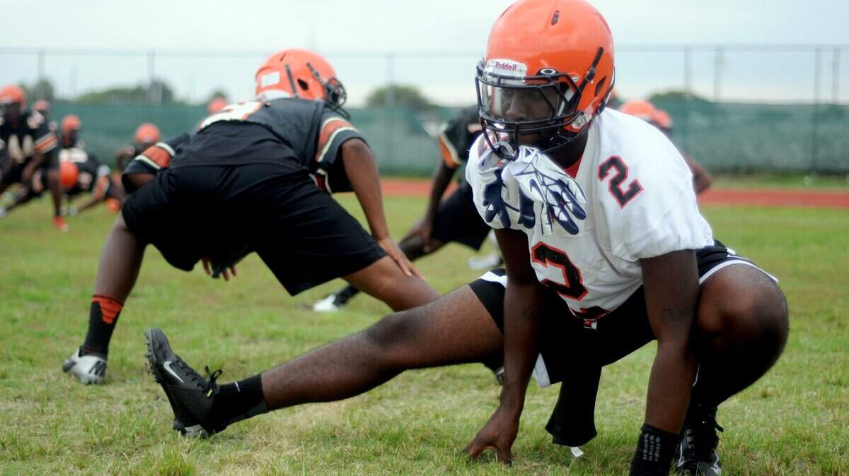 Theodore Hammonds (2) stretches as he gets ready for Carol City High School’s first practice of the season. On Tuesday, Warner University announced Hammonds had died after collapsing during practice.